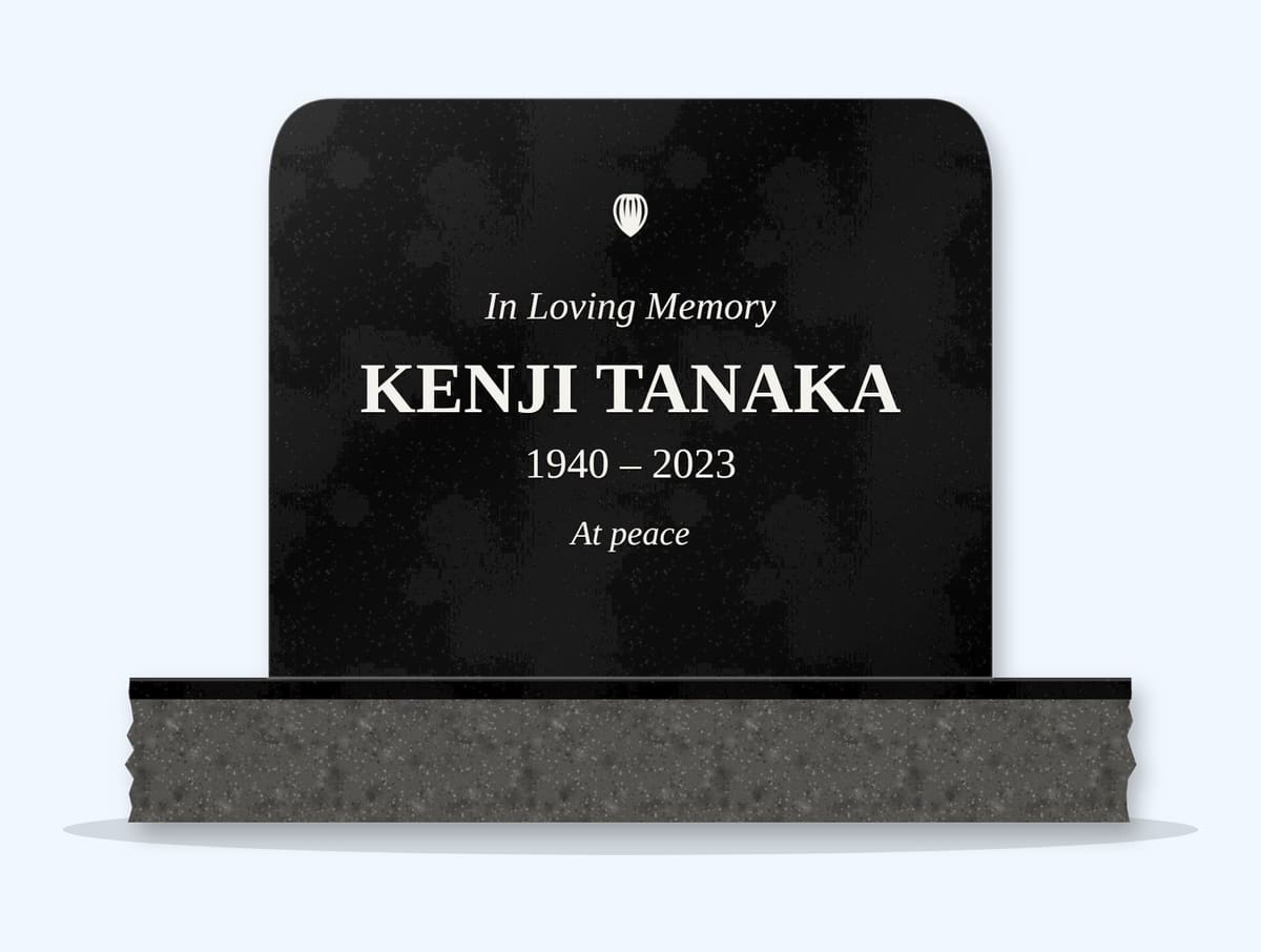 Absolute Black rounded top headstone on a granite base, engraved for Kenji Tanaka